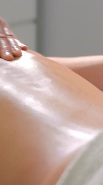 Genç bir kadın sakin bir kaplıcada terapi amaçlı sırt masajından hoşlanıyor. Eğitimli bir terapist, sağlık ve rahatlama için derin sırt masajı yapar..