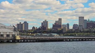 New York ABD 16.10.2024: Brooklyn Rıhtımı Ağaçlı ve Helikopterli Uçan Doğu Nehri İskelesi Bulutlu Mavi Gökyüzü, şehir mimarisi ve taşımacılığının editoryal manzarası.