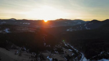 Karpatya Dağları Gün Doğumu Görünümü Dağ tepelerinde yükselen parlak güneşle ve kar ormanları ve köylerle kaplı vadilerle doğanın manzaralı kış manzarası ve seyahat.