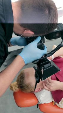 Bir dişçi hastanın dişinin fotoğrafını çeker. Bir doktor fotoğrafçı onun çalışmalarını fotoğrafçılığın yardımıyla yakalar. Fotoğraf raporu dişçilikte