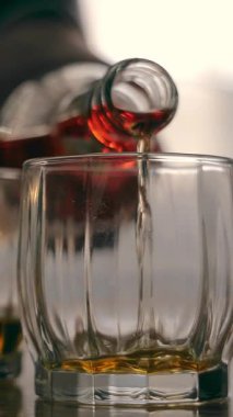 Bardaklara dökülen viski, bardaklara doldurulan kehribar viskisi, sıcak bir parıltıyla