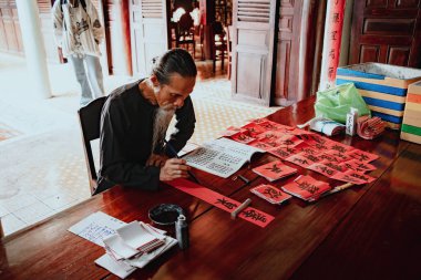 Vung Tau, Vietnam JAN 23 2022: Vietnamese scholar writes calligraphy at Long Son. Calligraphy festival is a popular tradition during Tet holiday. Writing couplets for Spring Festival at Luna new year