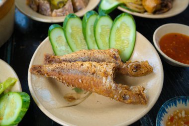 Vietnam family home cook set for four person: cooked rice, vegetable soup and fried fishes, fried onions with chicken, cucumber slice, Vietnamese Traditional Meal in Country side.
