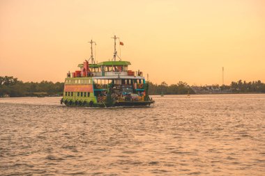 HO CHI MINH, VIETNAM - FEB 19 2022: A ferry brings commuters and vehicles from Cat Lai New Port to the opposite bank of the Nha Be River. Ho Chi Minh City is the largest city in Vietnam (9 mln)