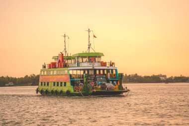 HO CHI MINH, VIETNAM - FEB 19 2022: A ferry brings commuters and vehicles from Cat Lai New Port to the opposite bank of the Nha Be River. Ho Chi Minh City is the largest city in Vietnam (9 mln)