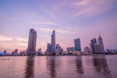 HO CHI MINH, VIETNAM - FEB 19 2022 : View of Bitexco Financial Tower building, buildings, roads, Thu Thiem bridge and Saigon river in Ho Chi Minh city in sunset. High quality panorama image.
