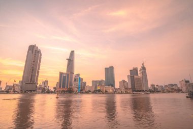HO CHI MINH, VIETNAM - FEB 19 2022 : View of Bitexco Financial Tower building, buildings, roads, Thu Thiem bridge and Saigon river in Ho Chi Minh city in sunset. High quality panorama image.