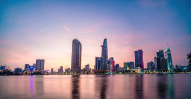 HO CHI MINH, VIETNAM - FEB 19 2022 : View of Bitexco Financial Tower building, buildings, roads, Thu Thiem bridge and Saigon river in Ho Chi Minh city in sunset. High quality panorama image.