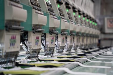 Modern and automatic high technology sewing machine for textile or clothing apparel making manufacturing process in industrial. Digital textile industry. Computerized embroidery.