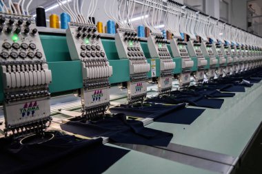 Modern and automatic high technology sewing machine for textile or clothing apparel making manufacturing process in industrial. Digital textile industry. Computerized embroidery.