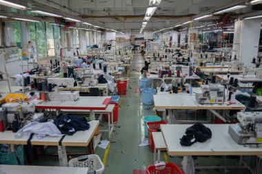 Ba Ria, VİETNAM - 18 MAR 2022: Tekstil kumaş fabrikası işçi terziliği için çalışıyor. Bu bir dikiş makinesi. Fabrika yapımı, boş işçi..