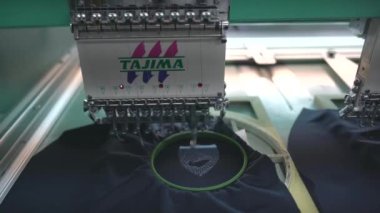 Ba Ria, VIETNAM - MAR 18 2022: Modern and automatic high technology sewing machine for textile or clothing apparel making manufacturing process in industrial. Close up Computerized embroidery machines