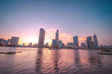 HO CHI MINH, VIETNAM - FEB 13 2022 : View of Bitexco Financial Tower building, buildings, roads, Thu Thiem bridge and Saigon river in Ho Chi Minh city in sunset. High quality panorama image.