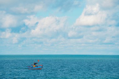 Tropical Seascape with a boat on sandy beach at cloudy sunrise or sunset. Beautiful sunset tropical beach with small boat and pink sky for travel and vacation in holiday relax time. Vung tau city.