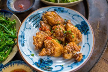 Fried chicken wings with fish sauce is a popular menu Traditional Meal in Country side. Vietnam family home cook set for four person