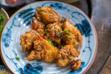 Fried chicken wings with fish sauce is a popular menu Traditional Meal in Country side. Vietnam family home cook set for four person