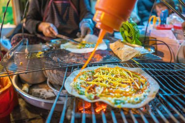 Close up Grilled girdle cake (Banh Trang Nuong) , a famous Vietnamese street stall eatery, a popular Vietnamese food in Da lat at night