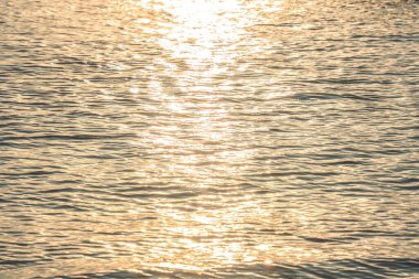 Sunset water reflect ripples at sun light. Abstract golden reflection on water sunset