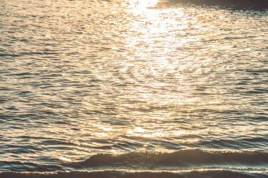 Sunset water reflect ripples at sun light. Abstract golden reflection on water sunset