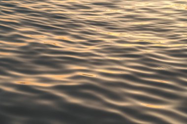 Sunset water reflect ripples at sun light. Abstract golden reflection on water sunset