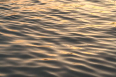 Sunset water reflect ripples at sun light. Abstract golden reflection on water sunset