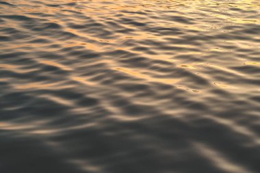 Sunset water reflect ripples at sun light. Abstract golden reflection on water sunset