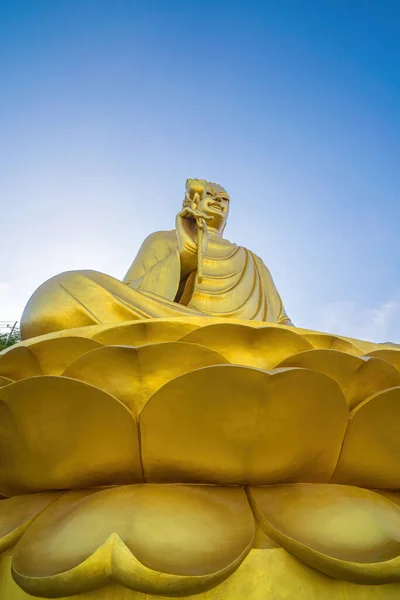 Golden Buddha statue's hand holding lotus at Chon Khong Monastery.
