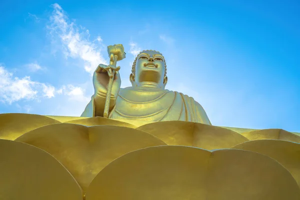 Golden Buddha statue's hand holding lotus at Chon Khong Monastery.