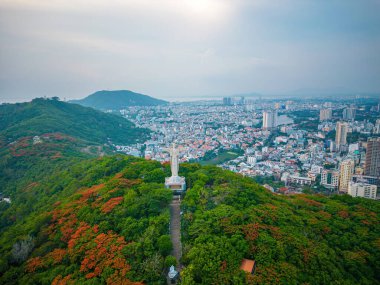 Vung Tau, Viet Nam - JUN 09 2022: Aerial view of Vung Tau with statue of Jesus Christ on Moutain . the most popular local place. Christ the King, a statue of Jesus. Travel concept.