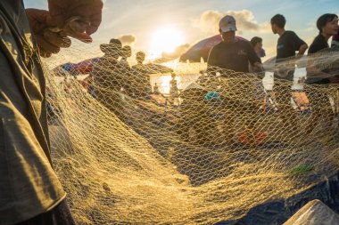 Fisherman casting his net at the sunrise or sunset. Traditional fishermen prepare the fishing net. Fishermen on beach at the Fishing.