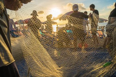 Fisherman casting his net at the sunrise or sunset. Traditional fishermen prepare the fishing net. Fishermen on beach at the Fishing.