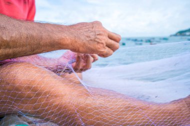 Fisherman casting his net at the sunrise or sunset. Traditional fishermen prepare the fishing net. Fishermen on beach at the Fishing.