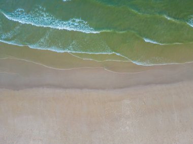 Havadan kumsal manzarası, yaz tatili şablonu afişi. Dalgalar inanılmaz mavi okyanus gölü, deniz kıyısı, kıyı şeridi ile sörf yapar. Mükemmel bir hava aracı üst görüntüsü. Huzurlu, parlak sahil, deniz kenarı.