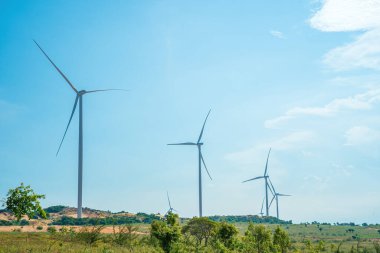 Panoramic view of wind farm or wind park, with high wind turbines for generation electricity with copy space at Phan Thiet, Mui Ne, Bau Trang. Green energy concept.