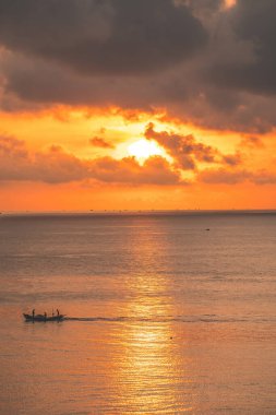 Beautiful cloudscape over the sea, sunrise shot. Lonely boats. Calm sea with sunset sky and sun through the clouds over. Calm sea with sunset sky or sunrise and sun through the clouds over.