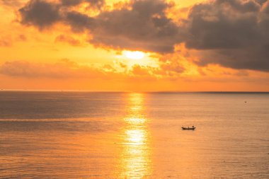 Beautiful cloudscape over the sea, sunrise shot. Lonely boats. Calm sea with sunset sky and sun through the clouds over. Calm sea with sunset sky or sunrise and sun through the clouds over.