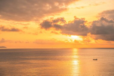 Beautiful cloudscape over the sea, sunrise shot. Lonely boats. Calm sea with sunset sky and sun through the clouds over. Calm sea with sunset sky or sunrise and sun through the clouds over.