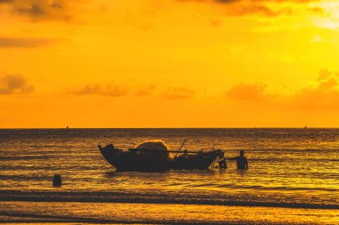 Beautiful cloudscape over the sea, sunrise shot. Lonely boats. Calm sea with sunset sky and sun through the clouds over. Calm sea with sunset sky or sunrise and sun through the clouds over.