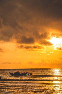 Beautiful cloudscape over the sea, sunrise shot. Lonely boats. Calm sea with sunset sky and sun through the clouds over. Calm sea with sunset sky or sunrise and sun through the clouds over.