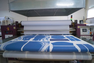 Ba Ria, VIETNAM - OCT 20, 2022: Havalandırma sistemli baskı odasında kumaş işleri için iç fabrika büyük ısı baskı makinesi. Endüstriyel ekipman ve teknoloji kavramı
