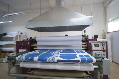 Ba Ria, VIETNAM - OCT 20, 2022: Havalandırma sistemli baskı odasında kumaş işleri için iç fabrika büyük ısı baskı makinesi. Endüstriyel ekipman ve teknoloji kavramı