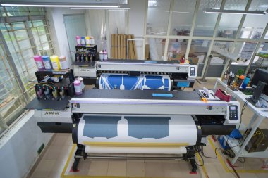 Ba Ria, VIETNAM - OCT 20, 2022 : Interior factory Large printing machine for paper business in printing room. Sublimation concept.