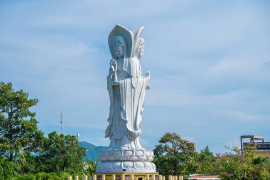 Majestic white Buddha statue on blue sky background. The Lady Buddha (the Bodhisattva of Mercy) at the Buu Lam Tu Pagoda which attracts tourists to visit spiritually on weekends in Vung Tau, Vietnam