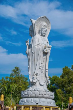 Majestic white Buddha statue on blue sky background. The Lady Buddha (the Bodhisattva of Mercy) at the Buu Lam Tu Pagoda which attracts tourists to visit spiritually on weekends in Vung Tau, Vietnam