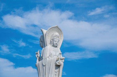 Majestic white Buddha statue on blue sky background. The Lady Buddha (the Bodhisattva of Mercy) at the Buu Lam Tu Pagoda which attracts tourists to visit spiritually on weekends in Vung Tau, Vietnam