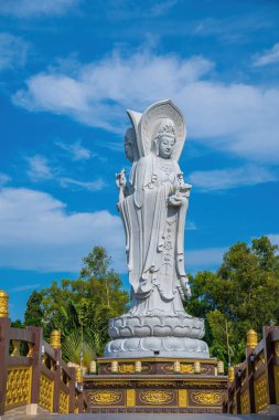 Majestic white Buddha statue on blue sky background. The Lady Buddha (the Bodhisattva of Mercy) at the Buu Lam Tu Pagoda which attracts tourists to visit spiritually on weekends in Vung Tau, Vietnam