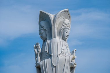 Majestic white Buddha statue on blue sky background. The Lady Buddha (the Bodhisattva of Mercy) at the Buu Lam Tu Pagoda which attracts tourists to visit spiritually on weekends in Vung Tau, Vietnam