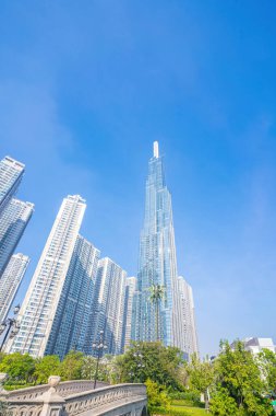 Morning view with sunny and green trees at Landmark 81 - it is a super tall skyscraper with development buildings along Saigon river in Ho Chi Minh city, Vietnam. Business, travel concept.