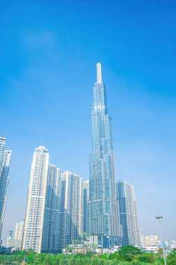 Aerial morning view with sunny and green trees at Landmark 81 - it is a super tall skyscraper with development buildings along Saigon river in Ho Chi Minh city, Vietnam. Business, travel concept.