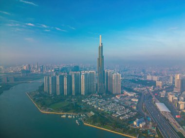 Aerial sunrise view at Landmark 81 - it is a super tall skyscraper and Saigon bridge with development buildings along Saigon river, cityscape in the beautiful morning with small fog around city